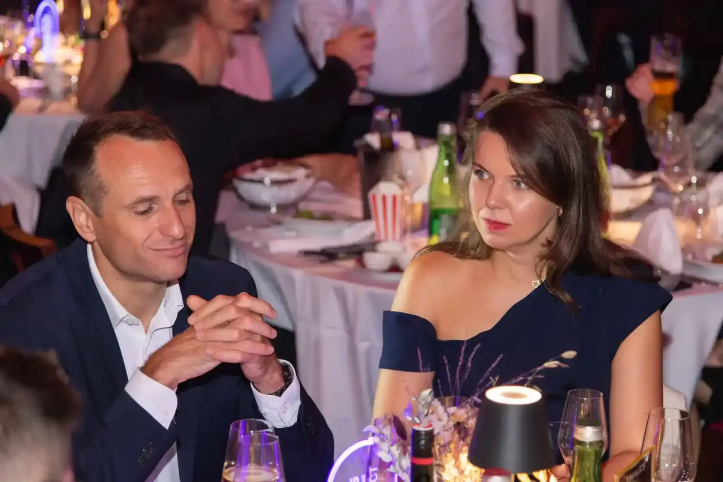 Zwei elegante Gäste bei einem Firmenevent Wien an gedecktem Tisch mit Getränken und Blumendekoration