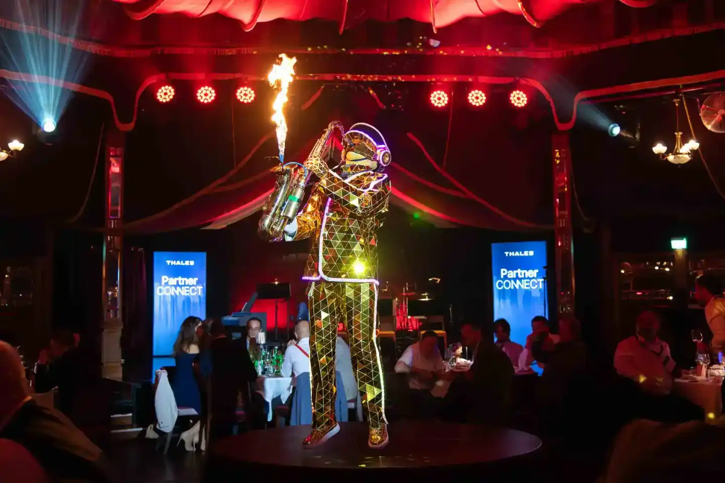 Spektakuläre Eventfotografie Wien: Leuchtende Kunstfigur mit Feuereffekt auf Bühne bei Thales Partner Connect Event