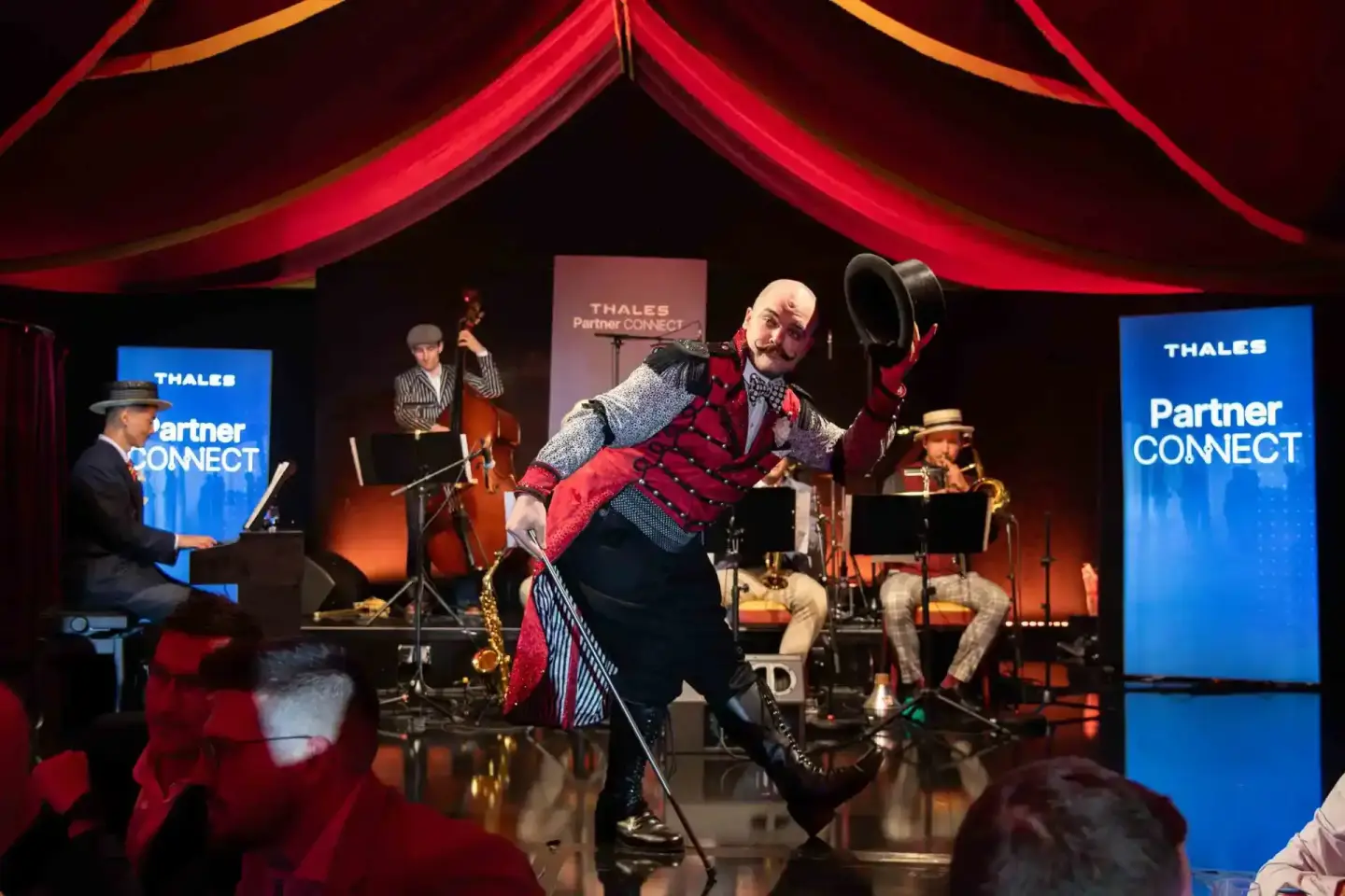 Performer in rotem Anzug bei Thales Partner Connect Veranstaltung mit Live-Band, Eventfotografie Wien