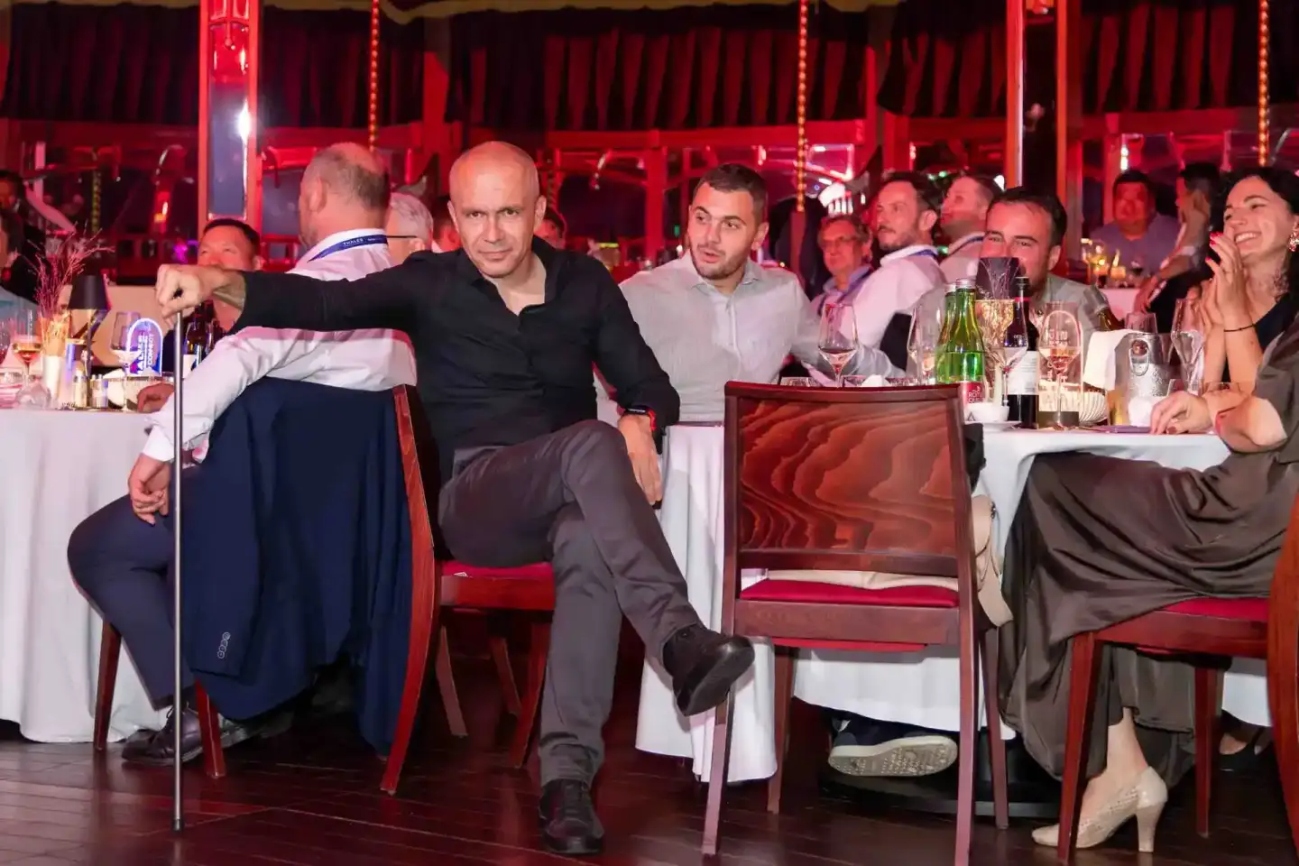 Gäste beim Thales Firmenevent in Wien sitzen an festlich gedeckten Tischen unter roter Beleuchtung und genießen die Veranstal