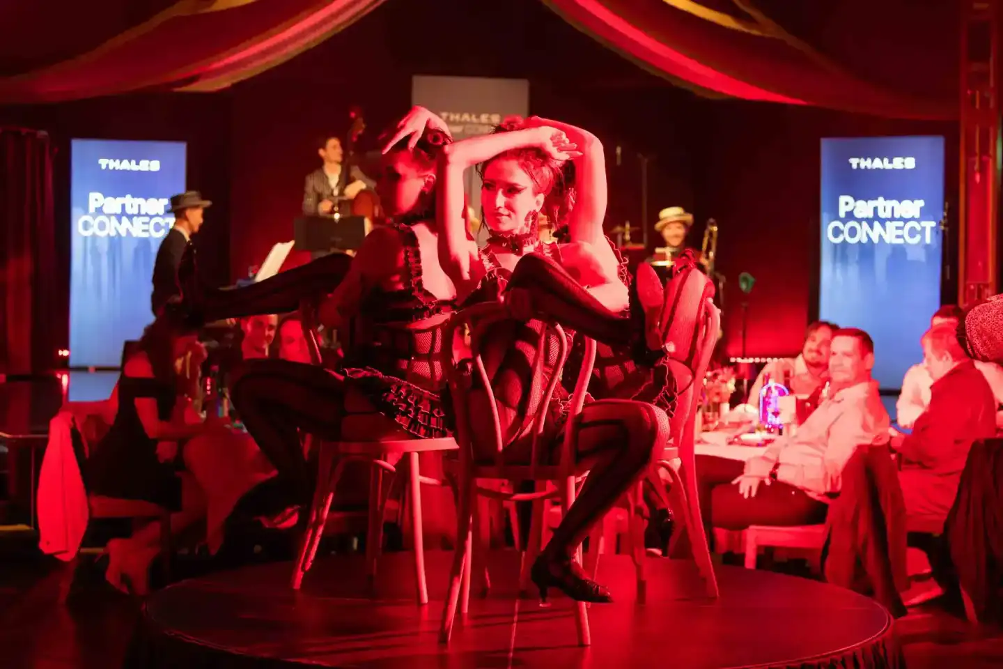 Eventfotografie Wien: Cabaret-Performance mit Künstlerin auf Stuhl bei Thales Partner Connect Event