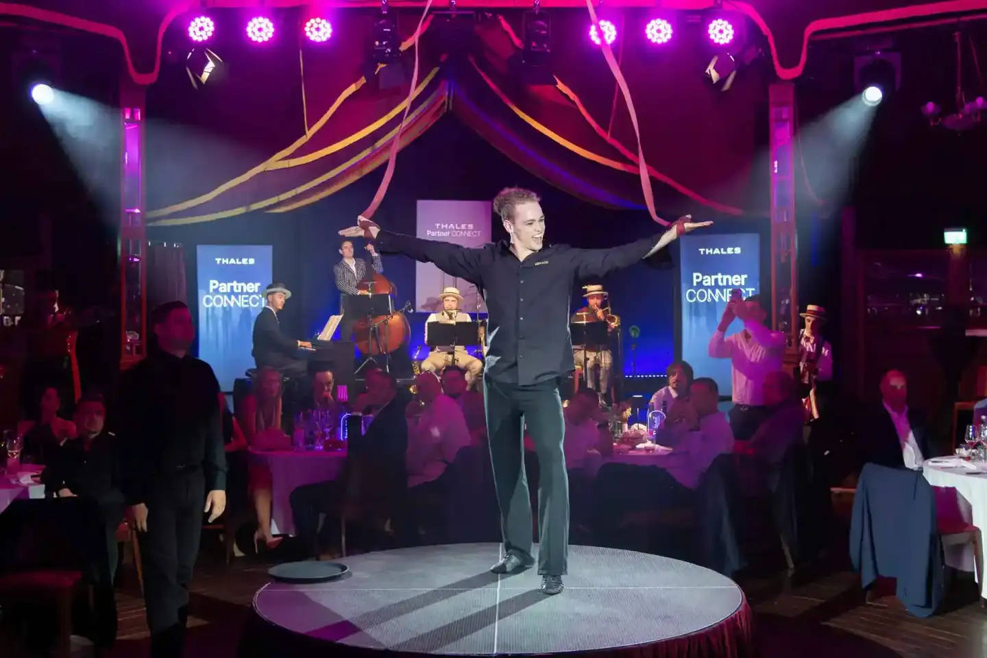 Eventfotograf dokumentiert Moderator auf der Bühne während Thales Partner Connect Veranstaltung in Wien