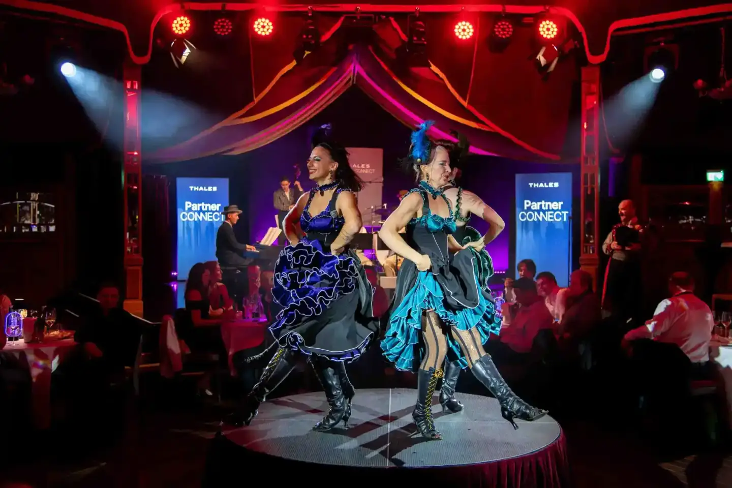 Zwei Performer in aufwendigen Kostümen auf der Bühne des Thales Partner Connect Events - professionelle Eventfotografie Wien