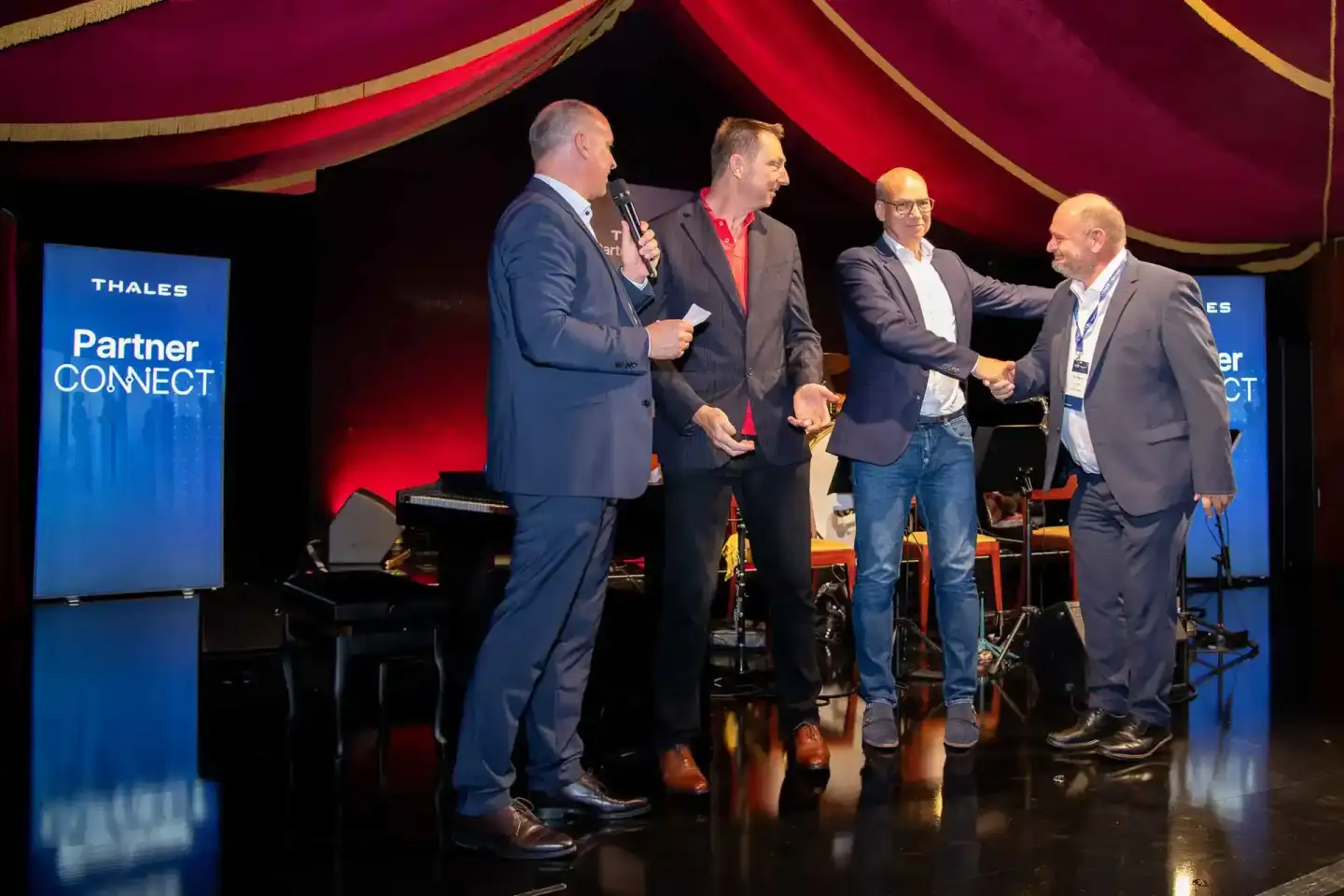 Vier Geschäftsmänner beim Thales Partner Connect Event auf der Bühne, Eventfotograf dokumentiert die Diskussionsrunde