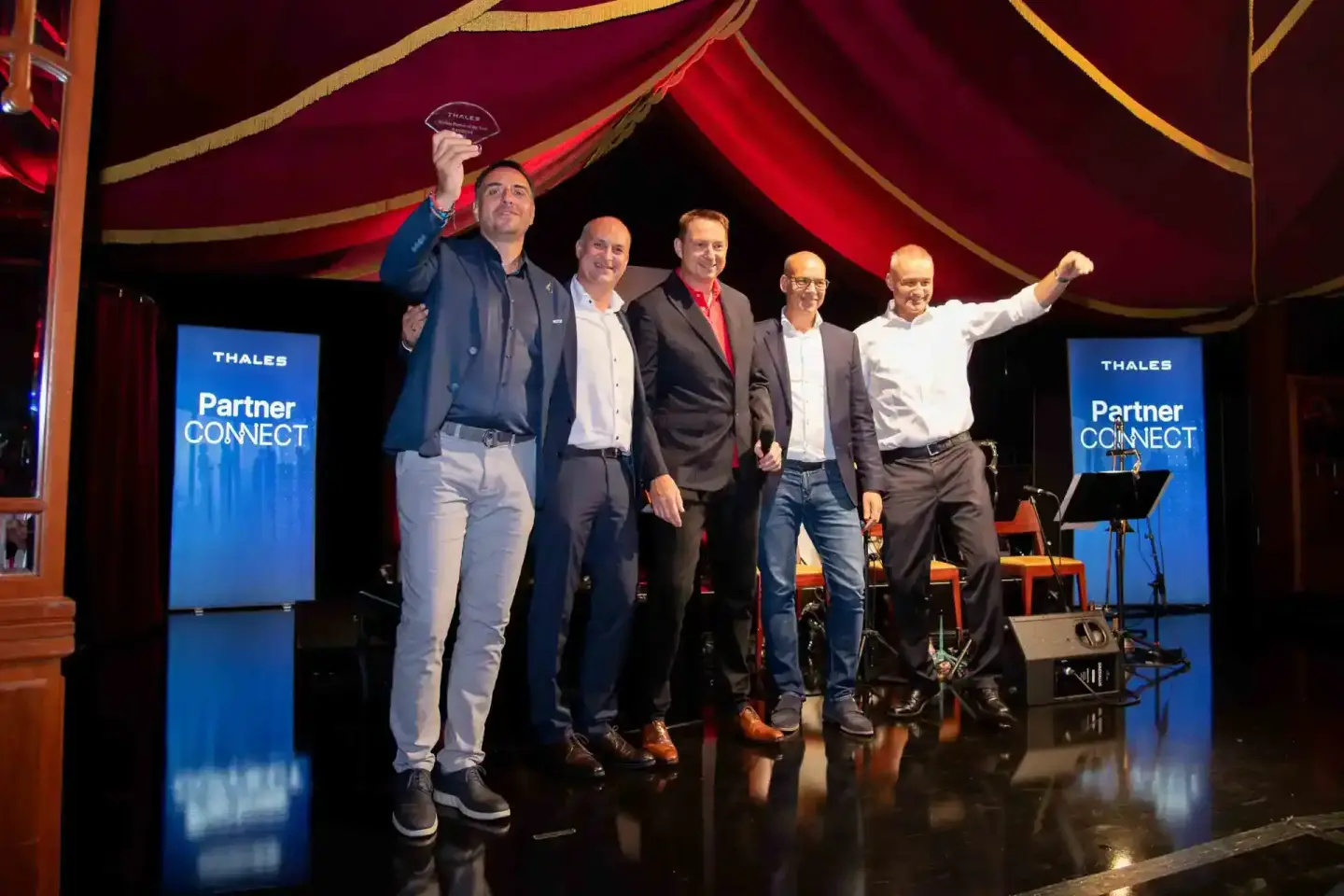 Sechs Geschäftsmänner auf einer Bühne mit Thales Partner Connect Branding, ein Mann hält einen Preis – Eventfotografie Wien