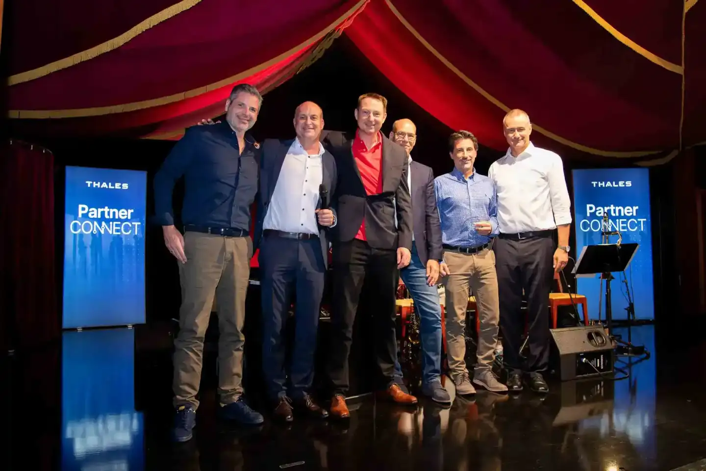 Sechs Geschäftsmänner auf der Bühne der Thales Partner CONNECT Veranstaltung in Wien, professionelle Eventfotografie