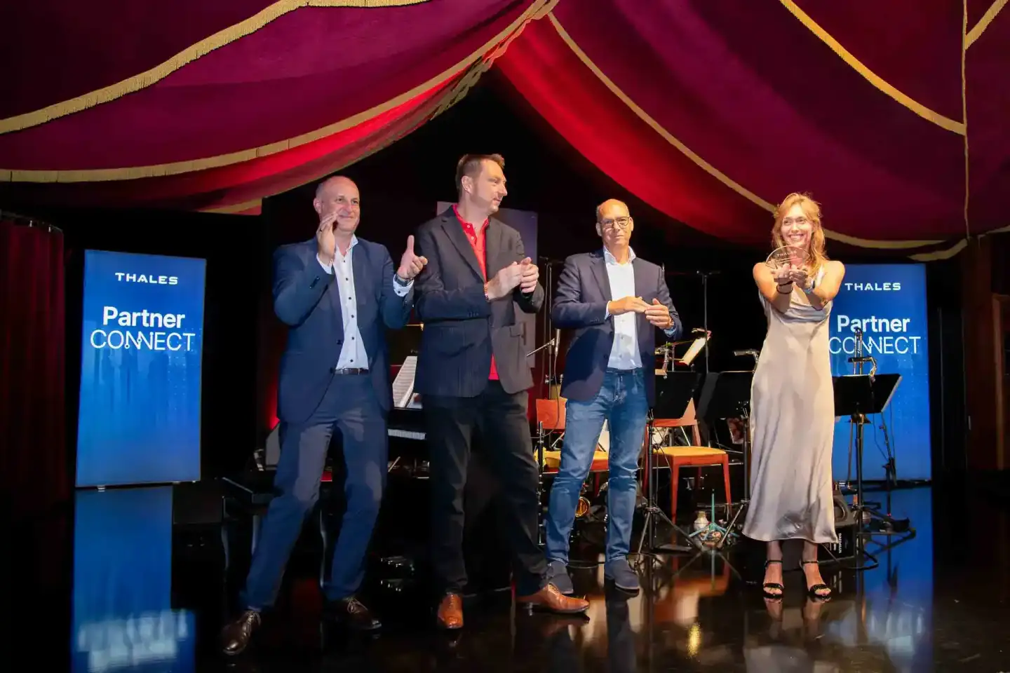 Vier Personen auf einer Bühne beim Thales Partner Connect Event, Eventfotograf Wien dokumentiert die Präsentation