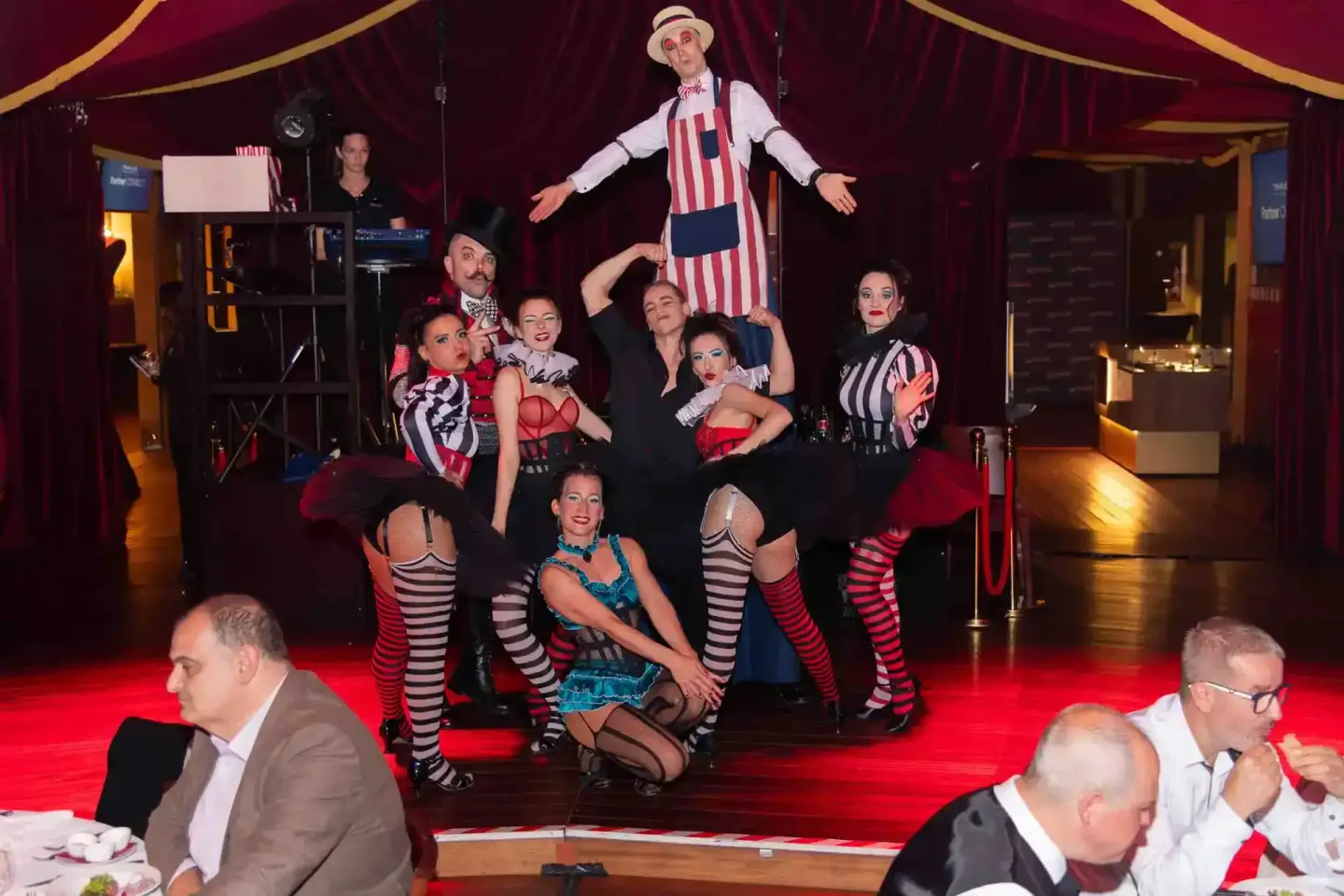 Zirkus-Show mit Akrobaten in rot-weißen Kostümen und gestreiften Strümpfen bei einem Firmenevent Wien