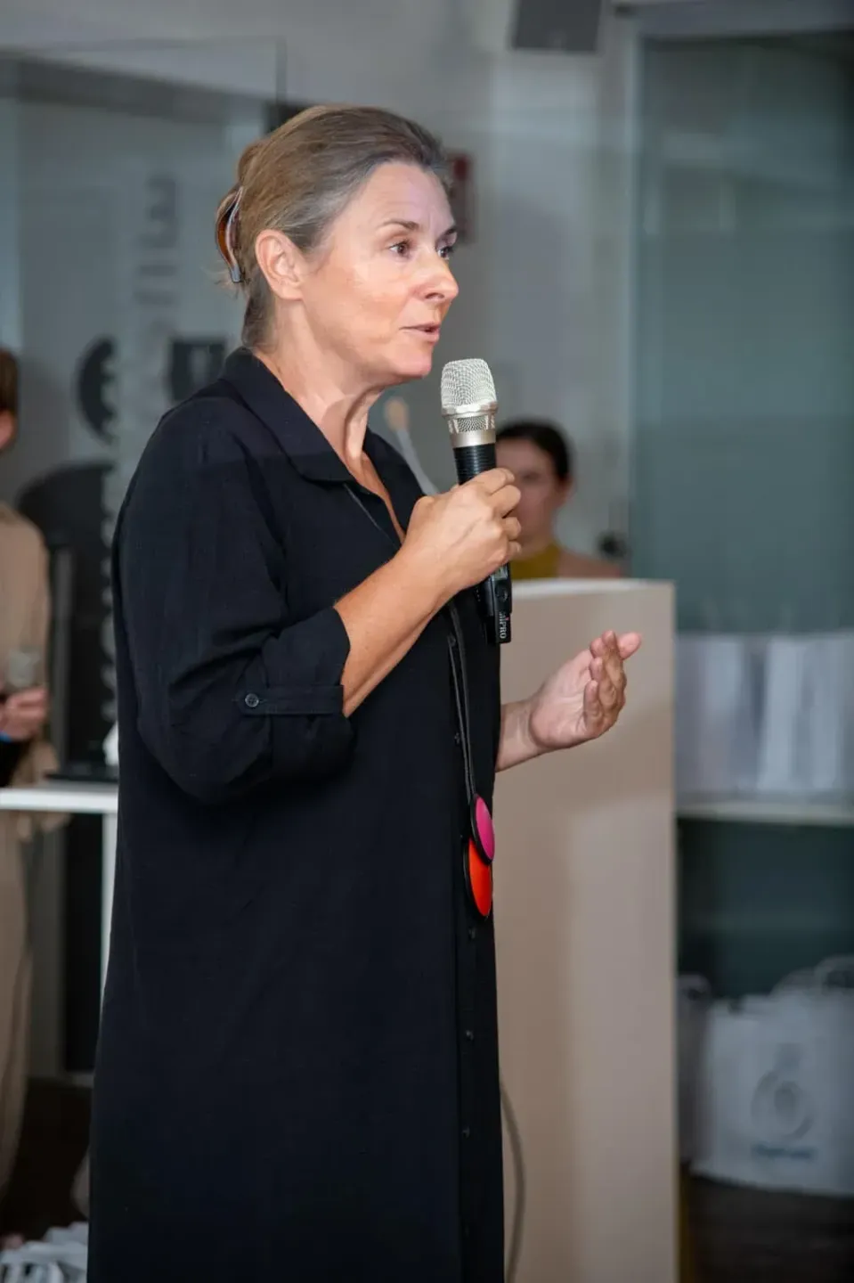 Sprecherin hält Vortrag mit Mikrofon auf Veranstaltung in Wien - Eventfotografie