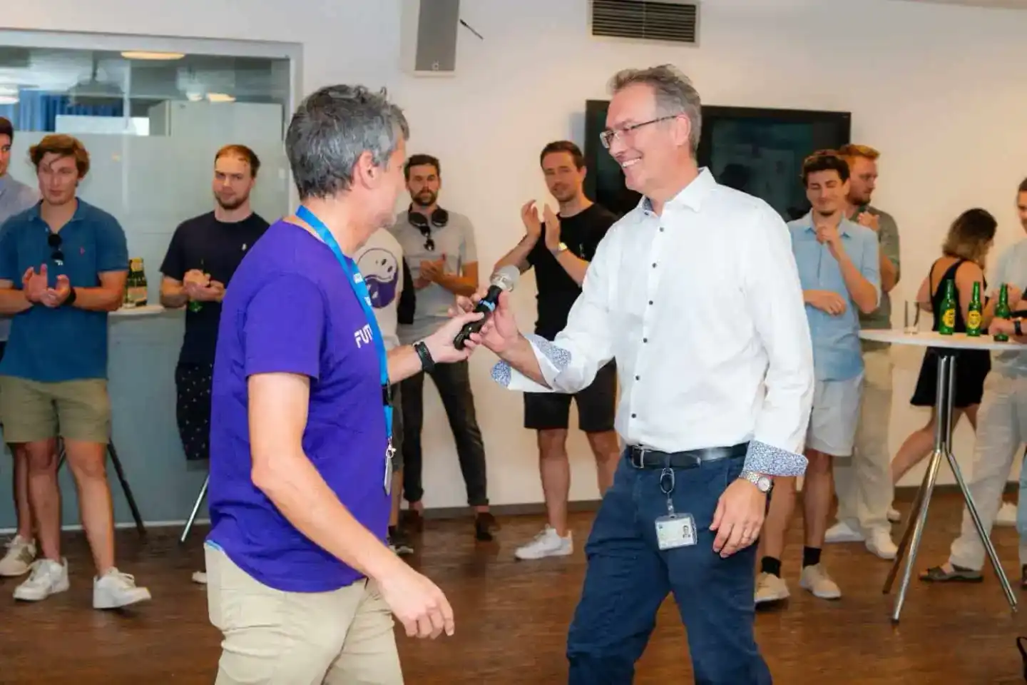 Eventfotograf dokumentiert Diskussion zwischen zwei Männern auf Firmenevent in Wien, Publikum im Hintergrund