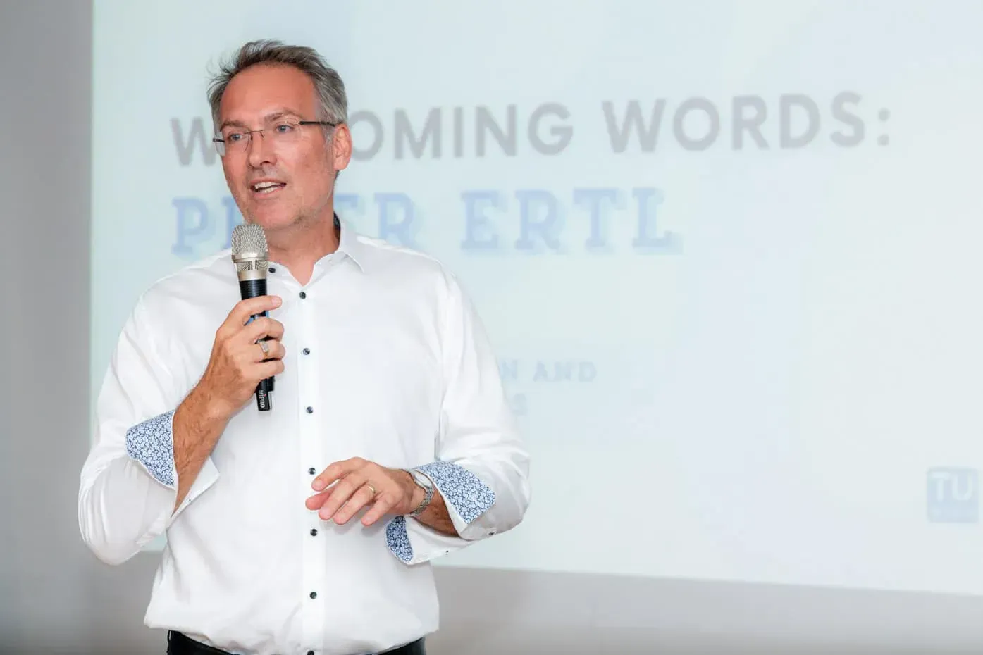 Sprecher bei Firmenevent Wien hält Präsentation mit Mikrofon vor Publikum