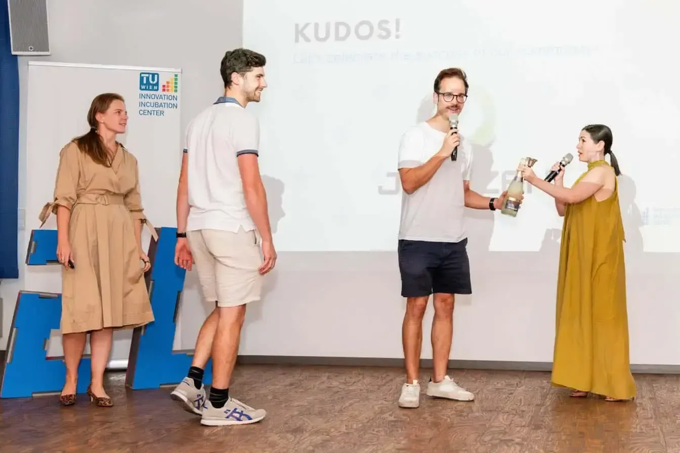 Vier Personen präsentieren ein Projekt auf der Bühne der TU Wien Innovation Incubation Center. Eventfotografie einer Startup-