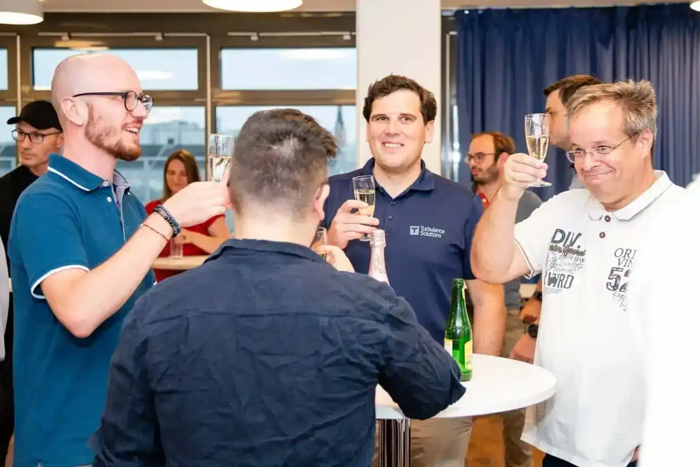 Eventfotograf Wien dokumentiert Firmenevent mit Gästen beim Anstoßen in modernem Konferenzraum mit Stadtblick