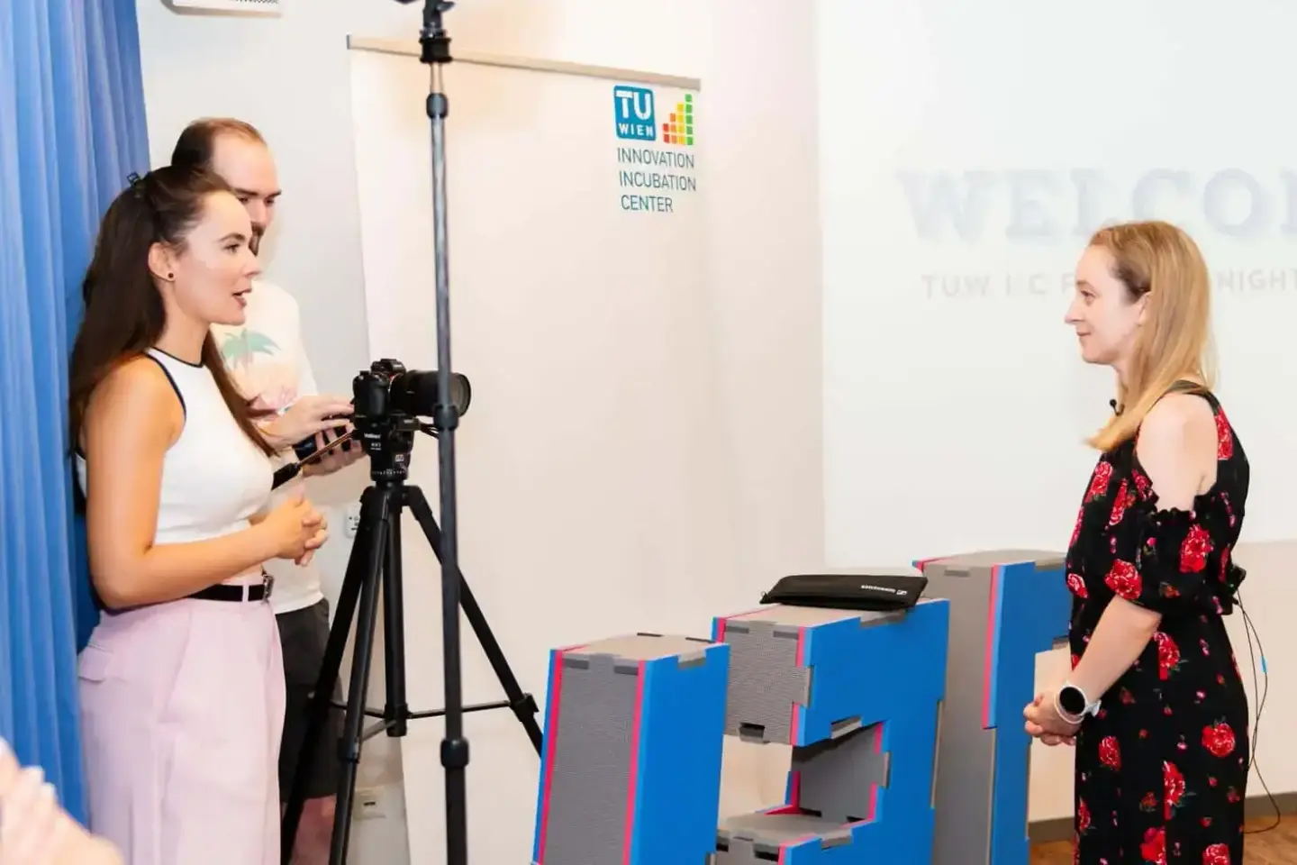 Eventfotografin filmt Interview mit Frau vor TU Wien Innovation Incubation Center Logo