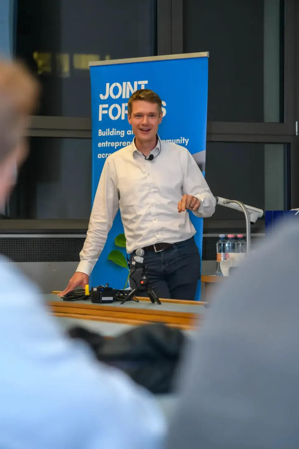 Junger Mann präsentiert an Podium bei TU Wien Event vor blauem Banner - Eventfotografie Wien
