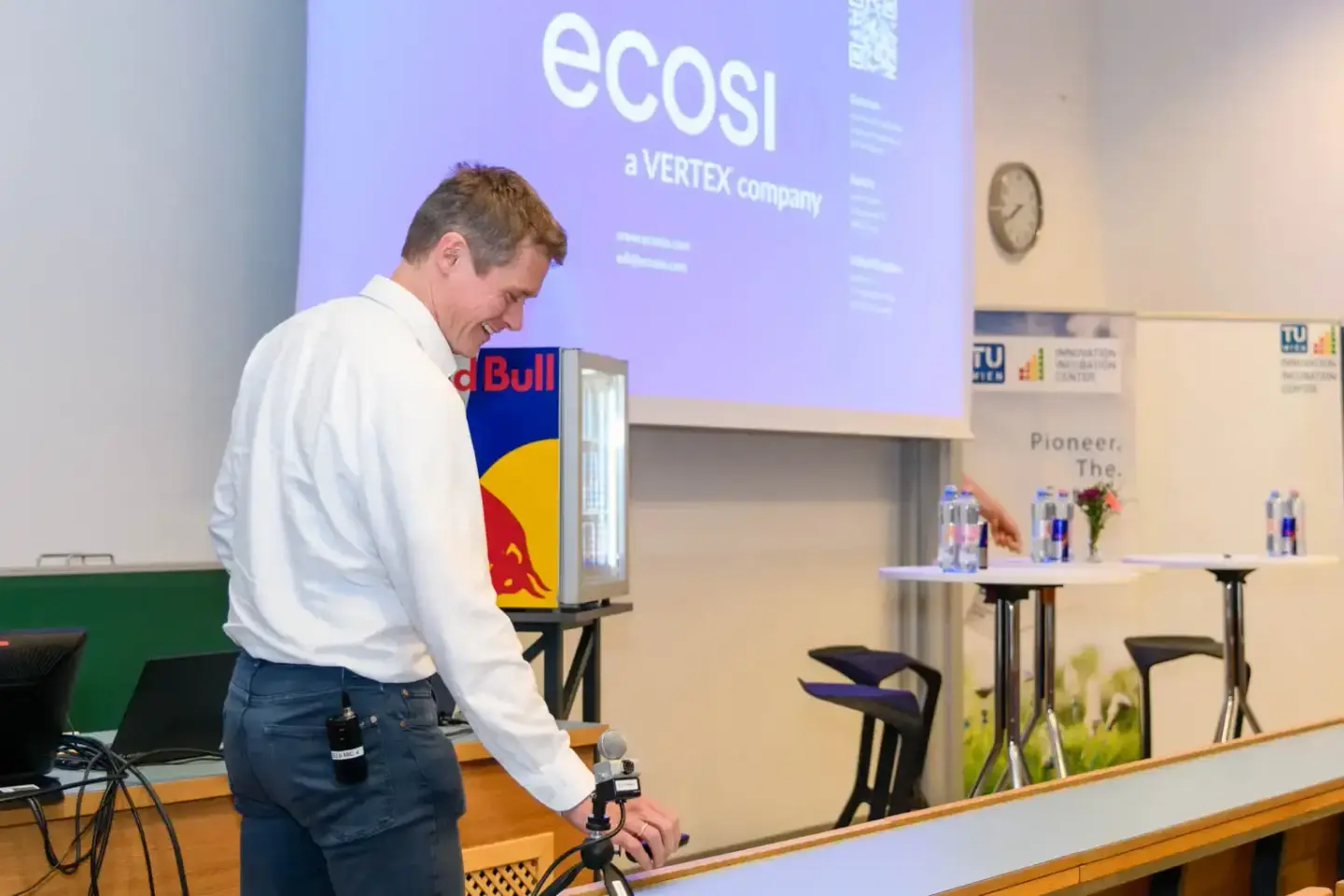 Redner mit Red Bull Kühlbox bei Veranstaltung an TU Wien mit ecosi Präsentation im Hintergrund - Eventfotograf Wien