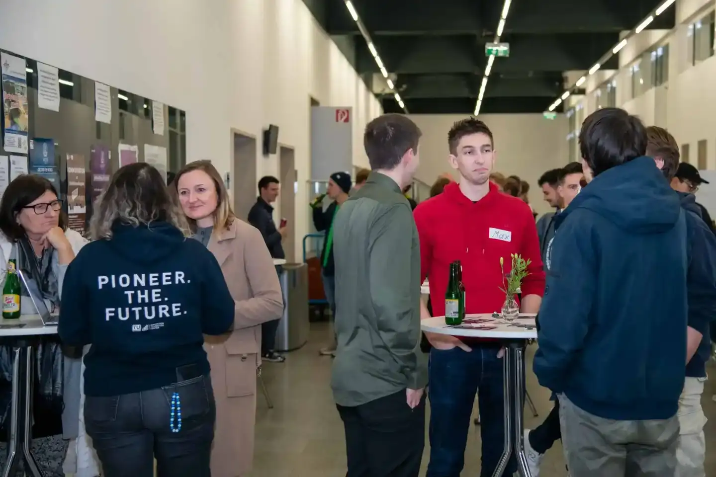 Eventfotografie einer TU Wien Veranstaltung mit Besuchern an Infoständen in moderner Halle