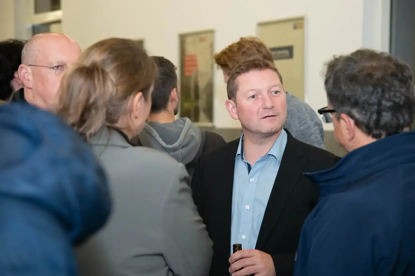 Eventfotograf dokumentiert Networking-Gespräche bei Veranstaltung in Wien mit mehreren Personen in moderner Hallenumgebung