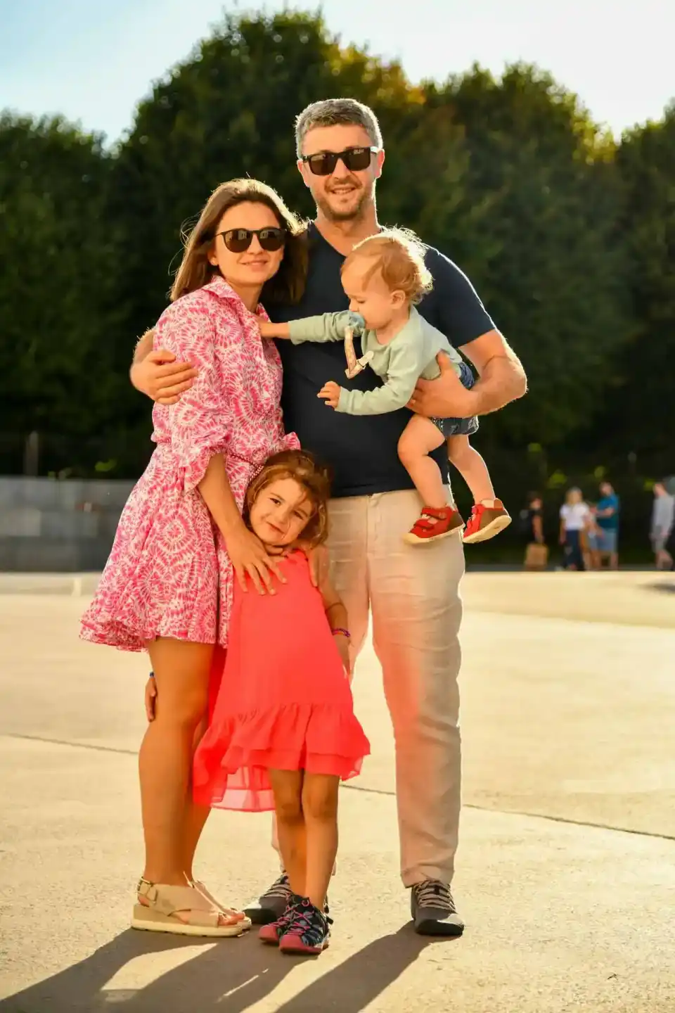 Glückliche Familie mit zwei Kindern und Baby posiert outdoor in der Sonne – Familienfotografie Wien