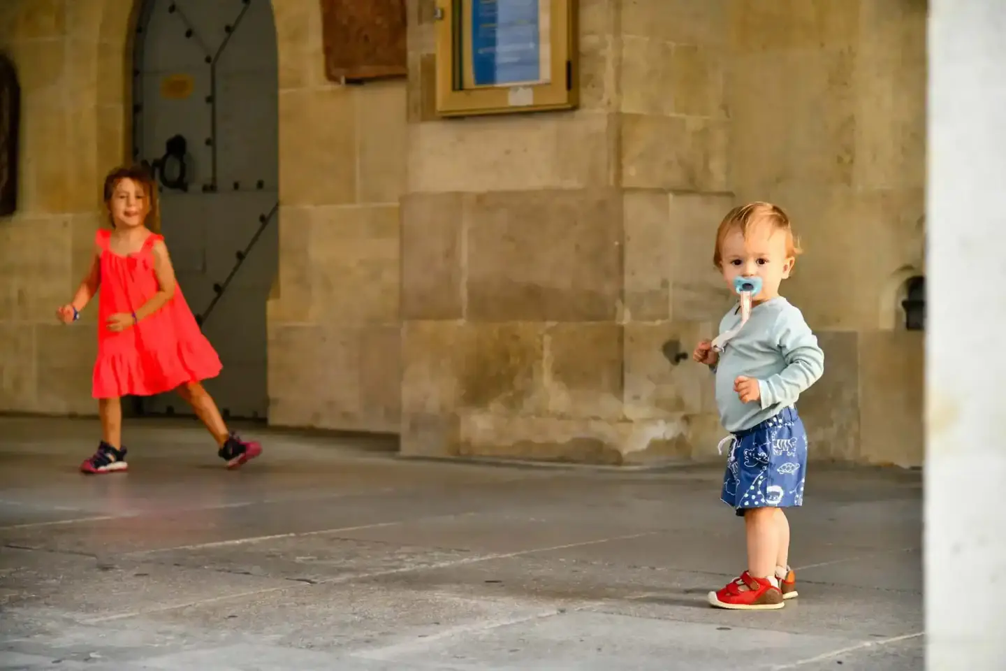 Zwei kleine Kinder spielen in einem historischen Innenhof – Familienfotografie Wien mit natürlichem Licht