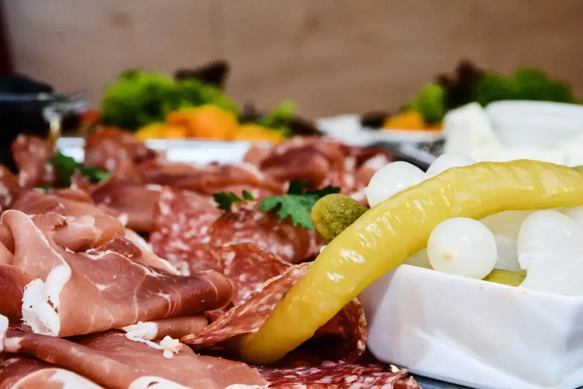 Elegante Charcuterie-Platte mit Prosciutto, Salami, eingelegten Gurken und Mozzarella - professionelle Foodfotografie Wien