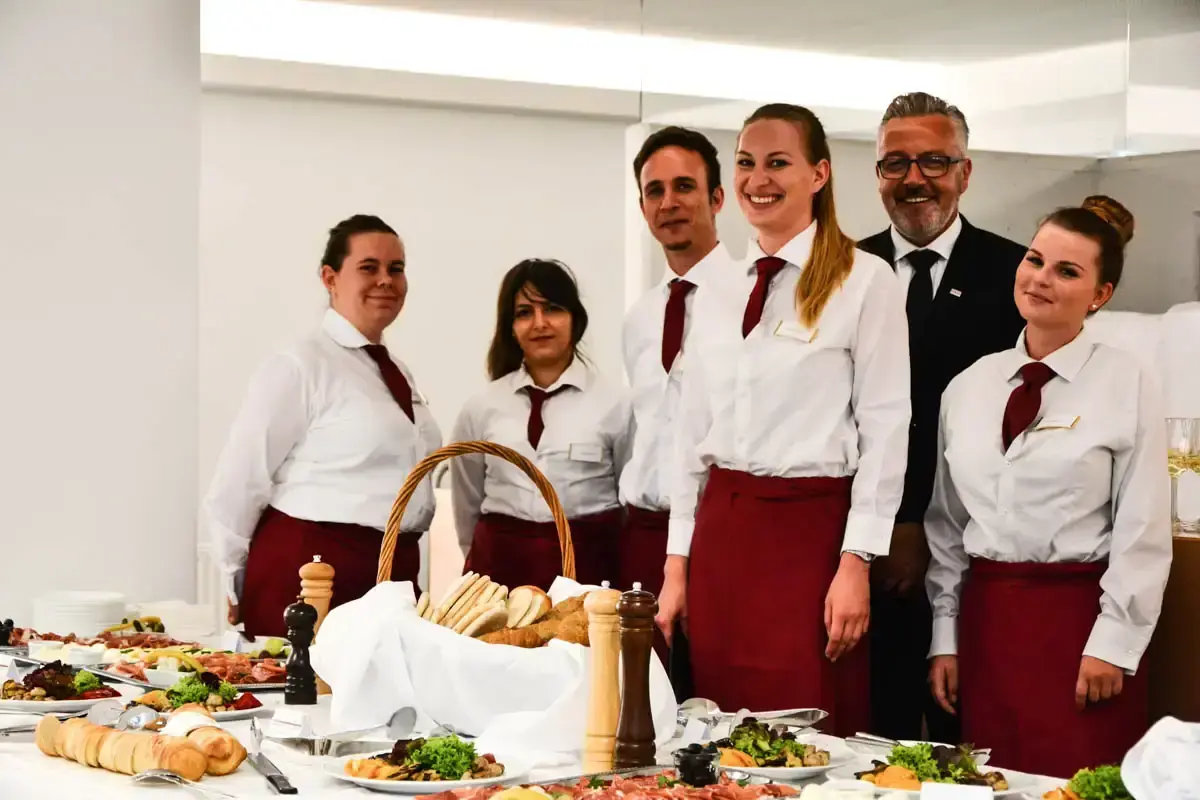 Professionelles Team in Restaurantuniform präsentiert appetitliche Speisen bei Food Fotografie Wien