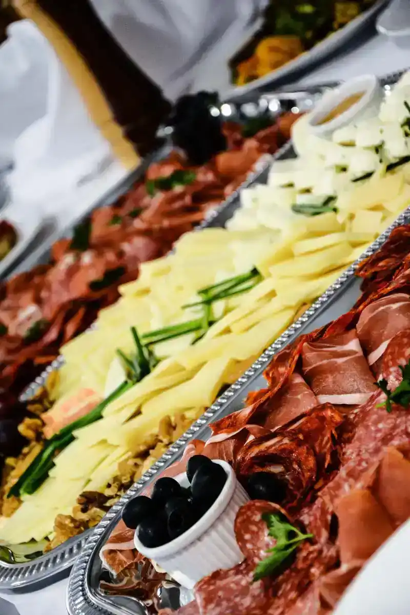 Elegante Charcuterie-Platte mit Käse, Cured Meats und schwarzen Oliven, professionell arrangiert von einem Food Fotograf Wien