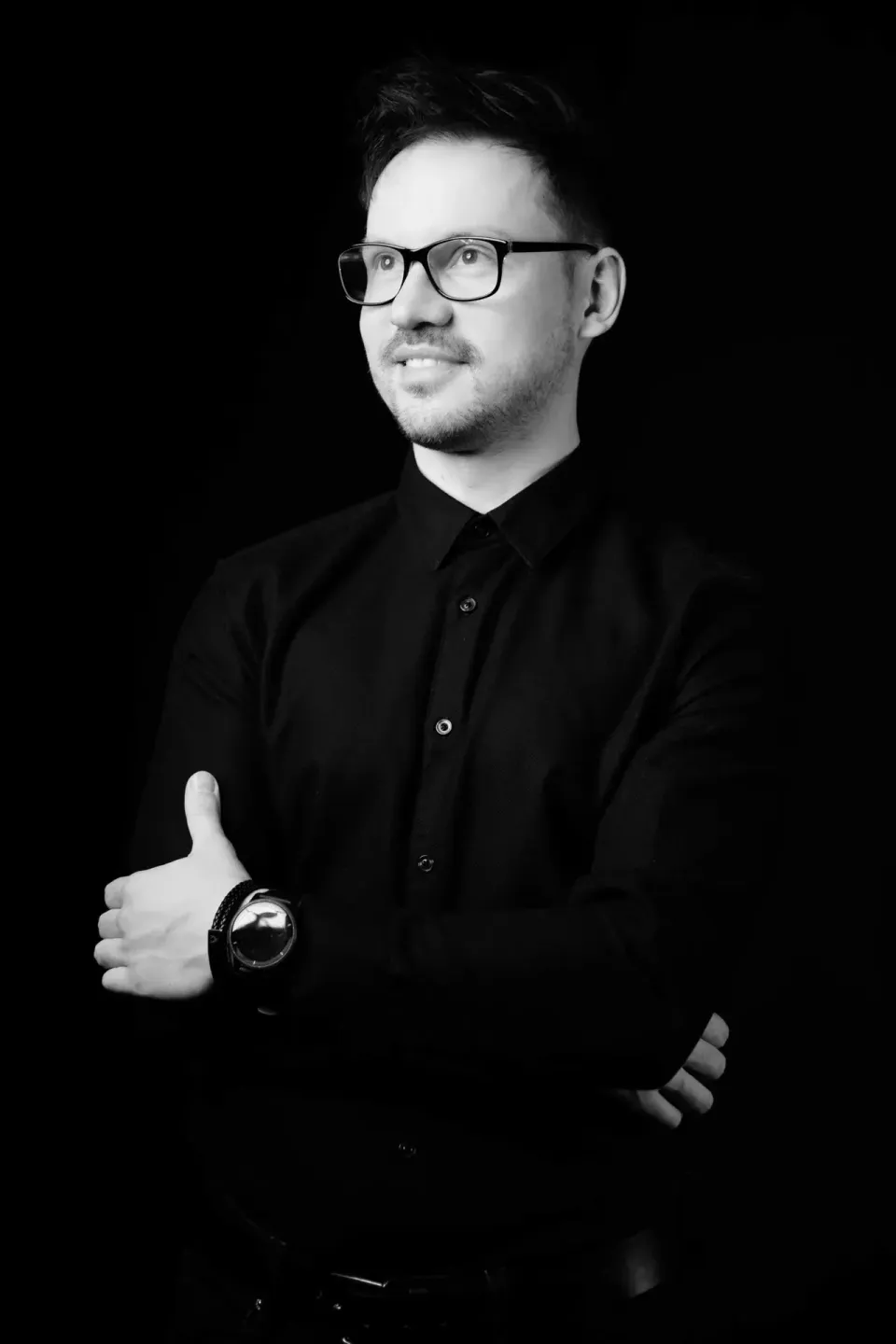 Professionelles schwarz-weißes Porträt eines Mannes mit Brille in schwarzem Hemd, Portraitfotograf Wien