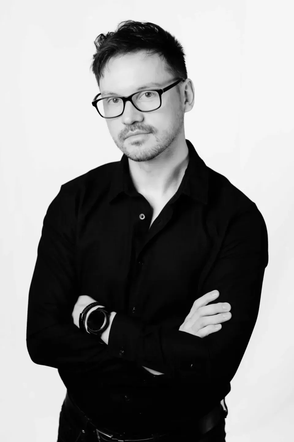 Portrait eines Mannes mit Brille in schwarzem Hemd vor weißem Hintergrund - professionelle Portraitfotografie Wien