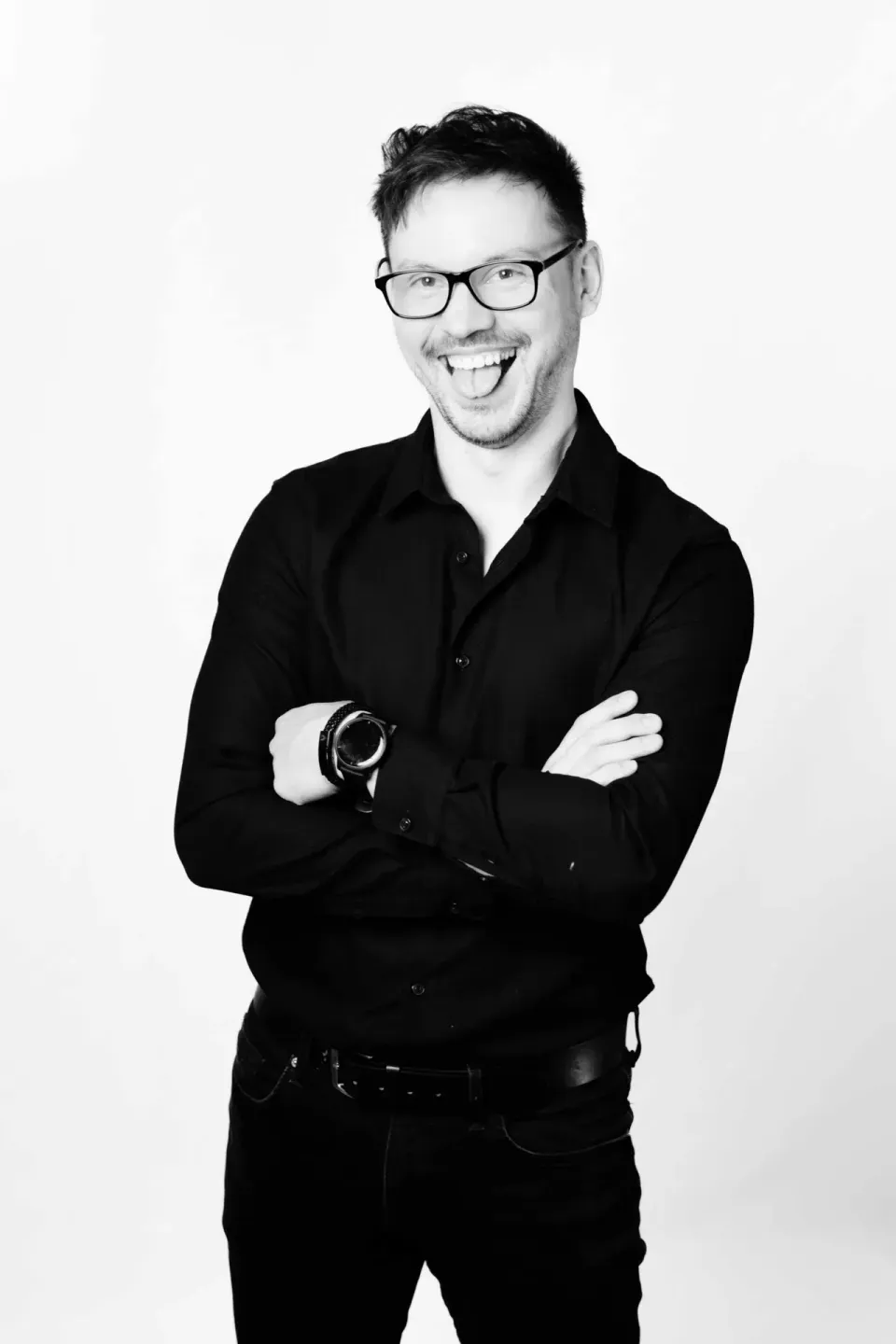 Professionelles Portrait eines Mannes mit Brille in schwarzem Hemd vor weißem Hintergrund - Portraitfotografie Wien