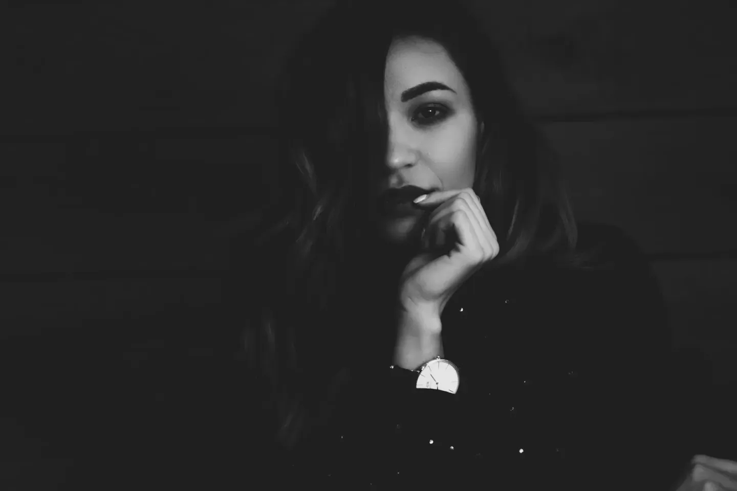 Nachdenkliche Porträtaufnahme einer Frau in Schwarzweiß mit Hand am Gesicht, professionelle Portraitfotografie Wien