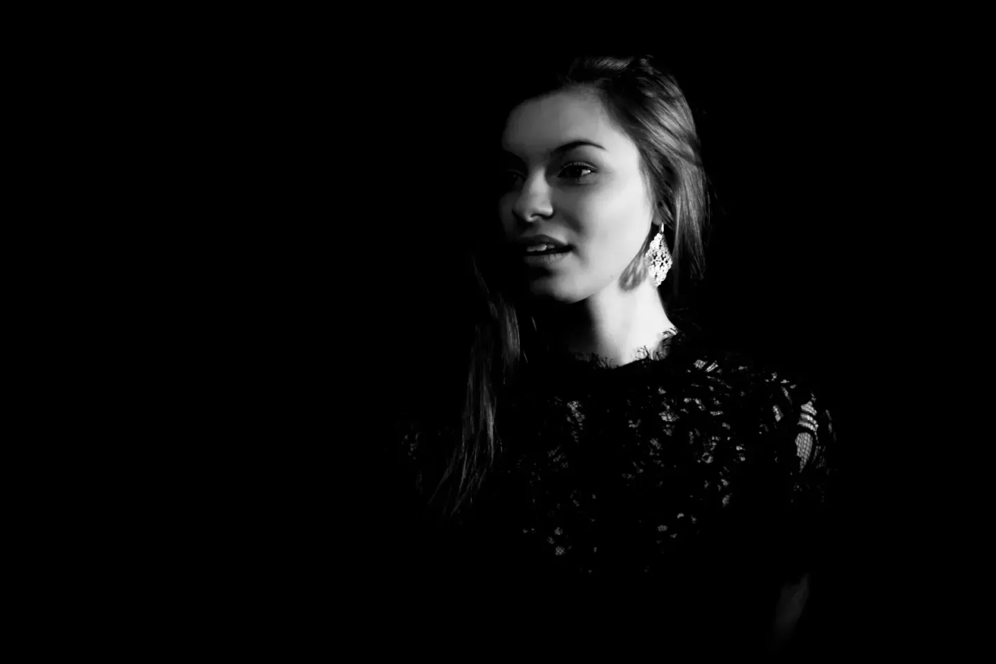 Elegantes Schwarz-Weiß Portrait einer Frau mit langen Haaren und Perlenohringen, professionelle Portraitfotografie Wien