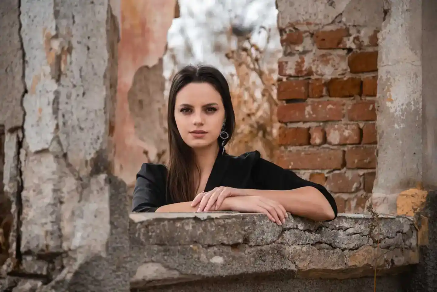 Porträt einer jungen Frau an einer Backsteinmauer, professionelles Portraitfotografie Wien