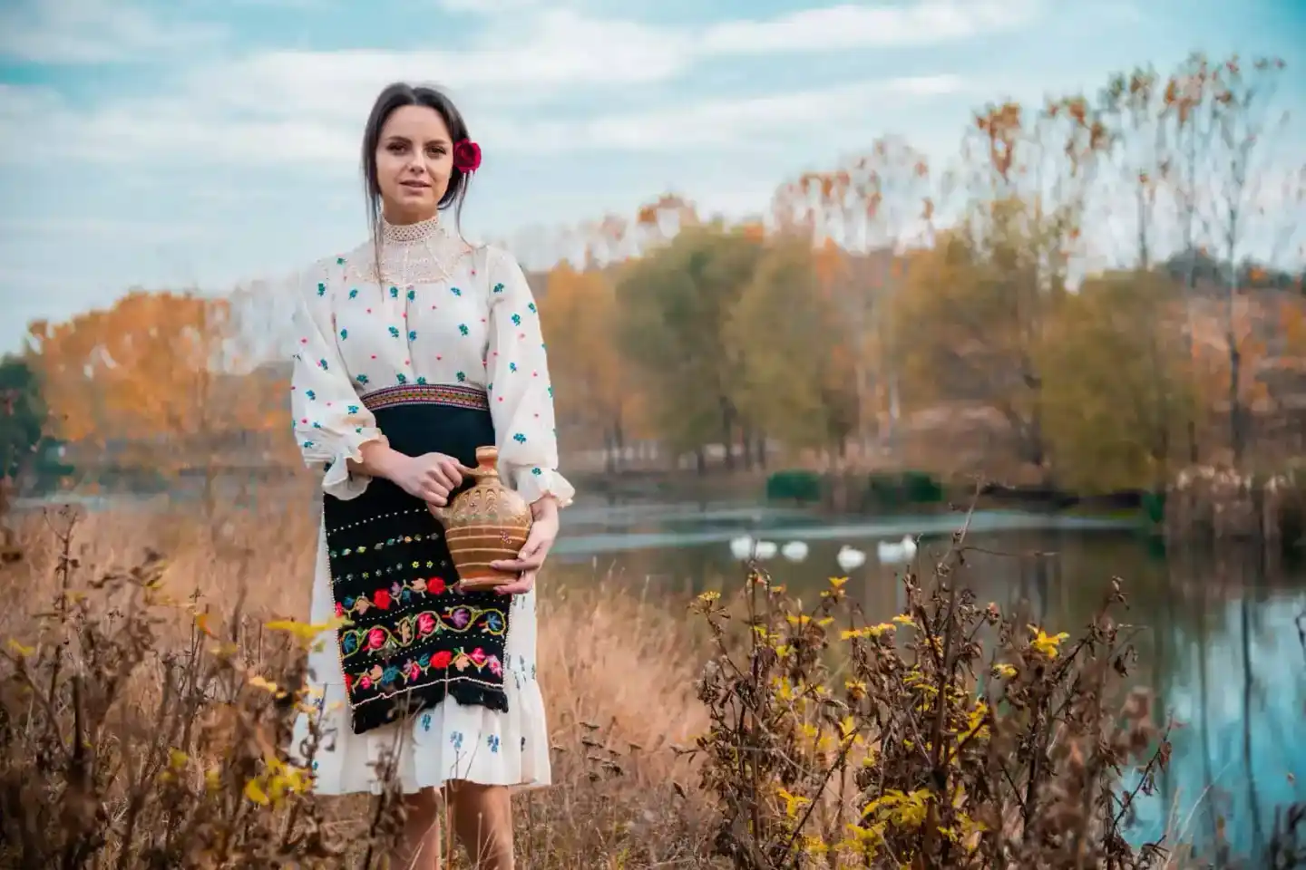 Portraitfotograf Wien: Junge Frau in traditioneller ukrainischer Tracht mit weißer bestickter Bluse und schwarzem Sarafan am 