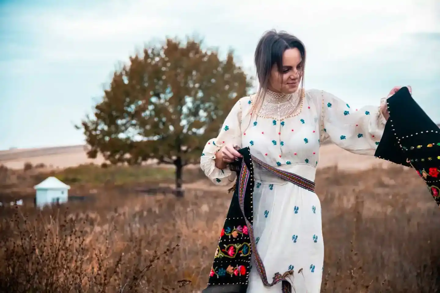 Frau in traditioneller ukrainischer Tracht mit besticktem Leinenhemd in ländlicher Landschaft, Portrait Wien