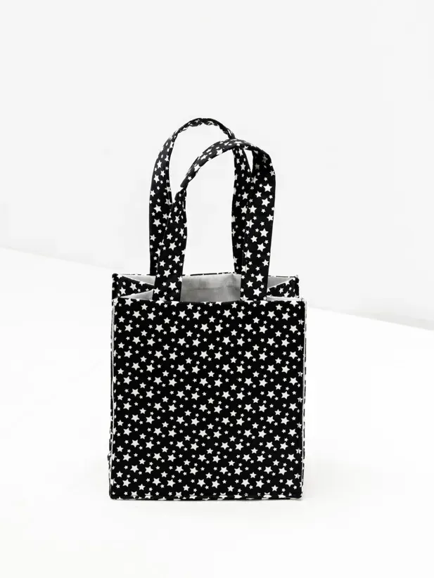 Schwarze Stofftasche mit weißem Sternmuster und zwei Henkeln, professionell fotografiert für E-Commerce Fotografie Wien