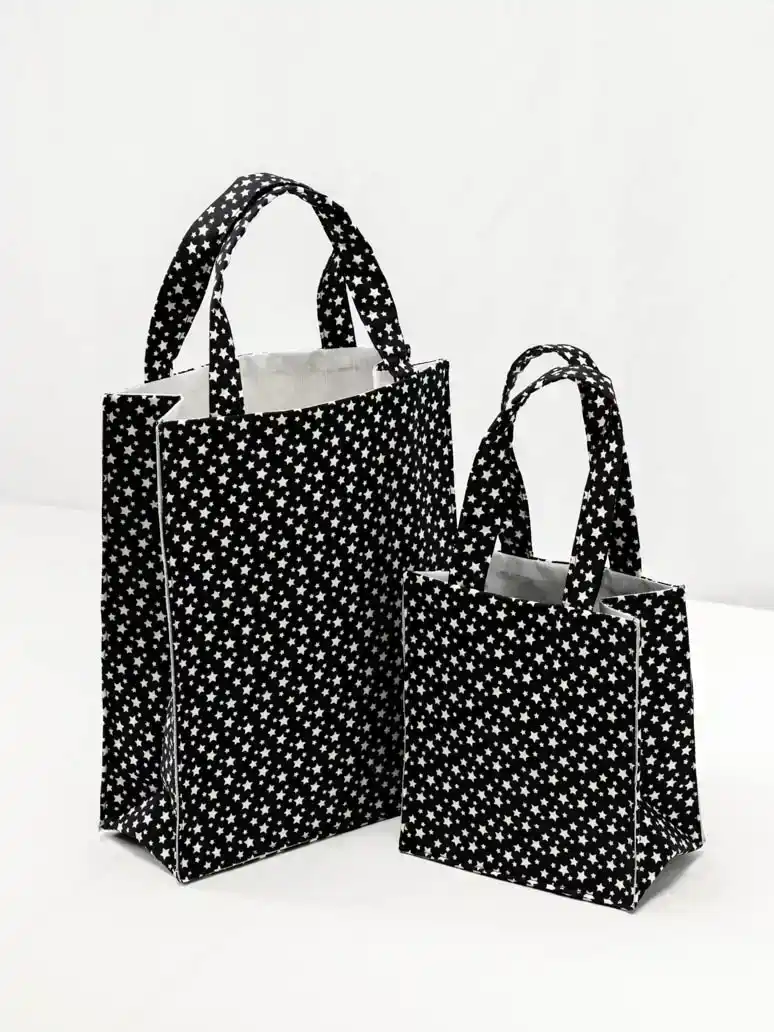 Zwei schwarze Einkaufstaschen mit weißem Sternmuster nebeneinander – professionelle Produktfotografie Wien