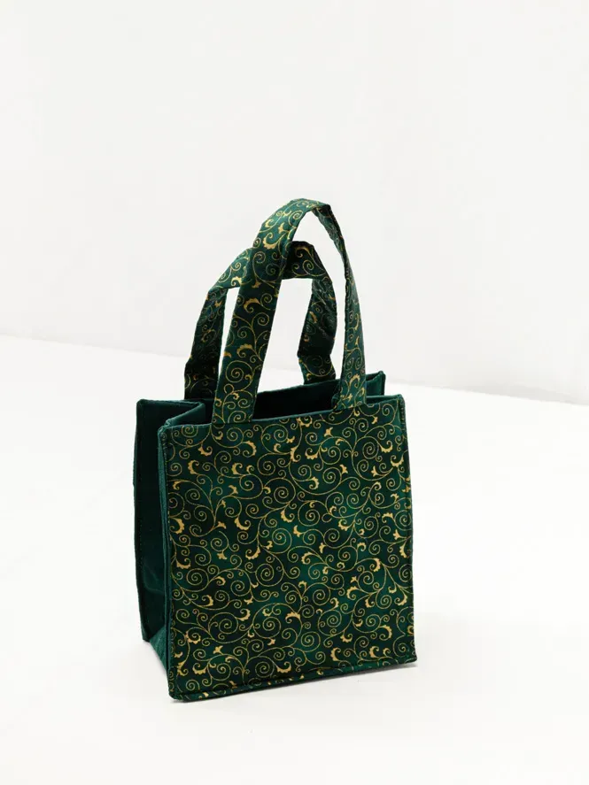 Grüne Stofftasche mit goldenen Ornamenten und Henkeln – professionelle Produktfotografie Wien