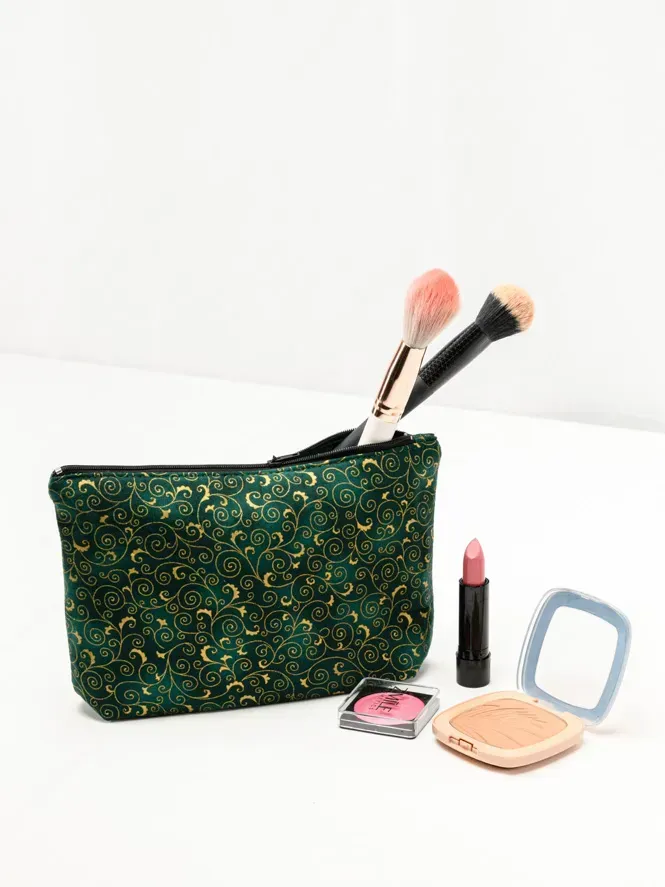 Professionelle Produktfotografie eines Make-up-Sets mit grüner Kosmetiktasche, Pinseln, Lippenstift und Puder