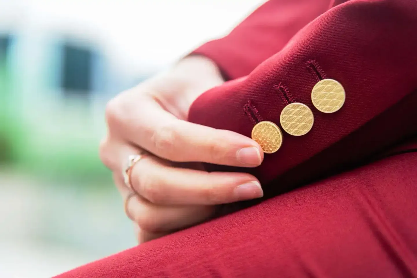 Frau in rotem Blazer mit goldenen Knöpfen und Ehering – Produktfotografie Wien
