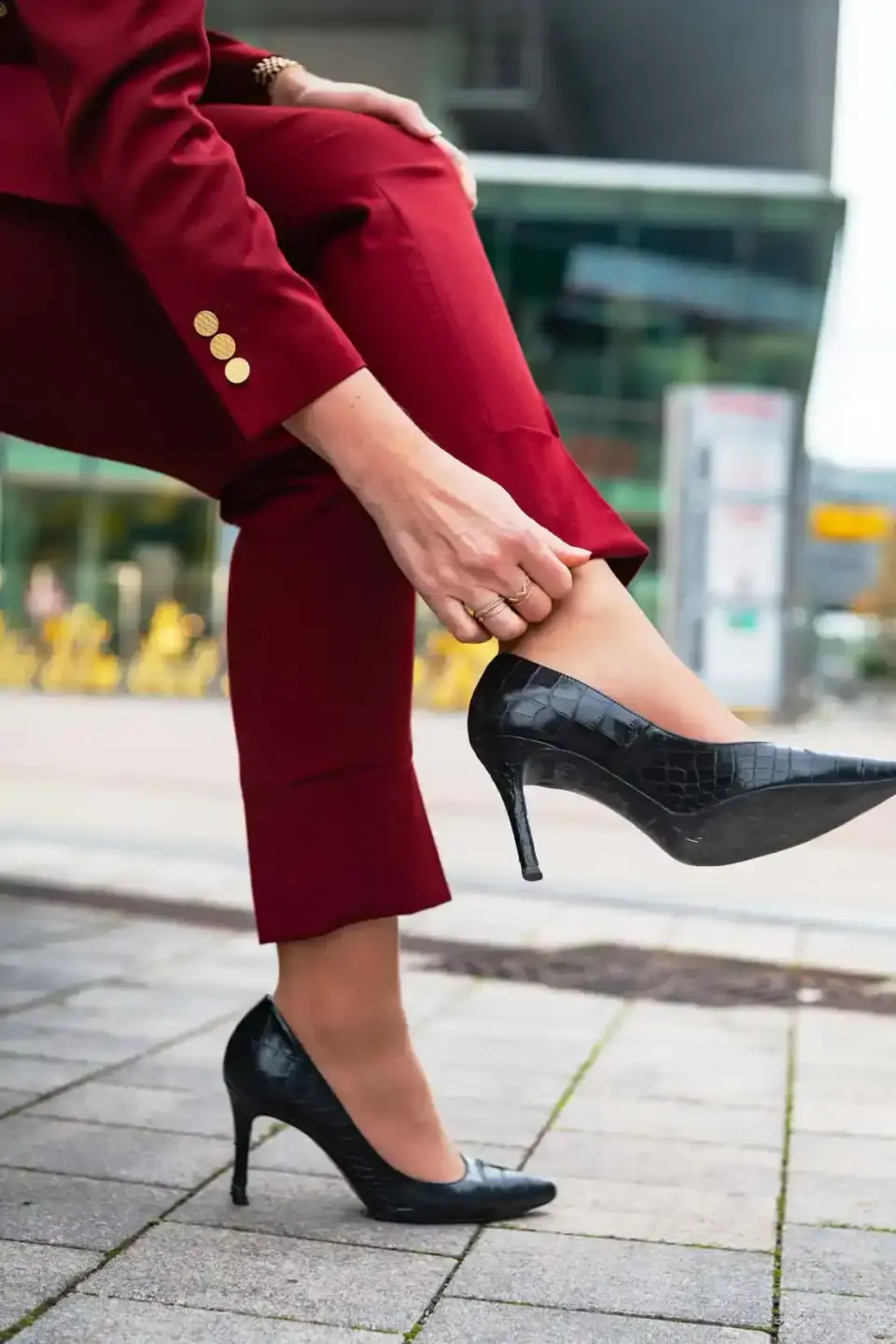 Frau in burgunderrotem Blazer mit schwarzen Krokodil-Pumps bei Produktfotografie in Wien