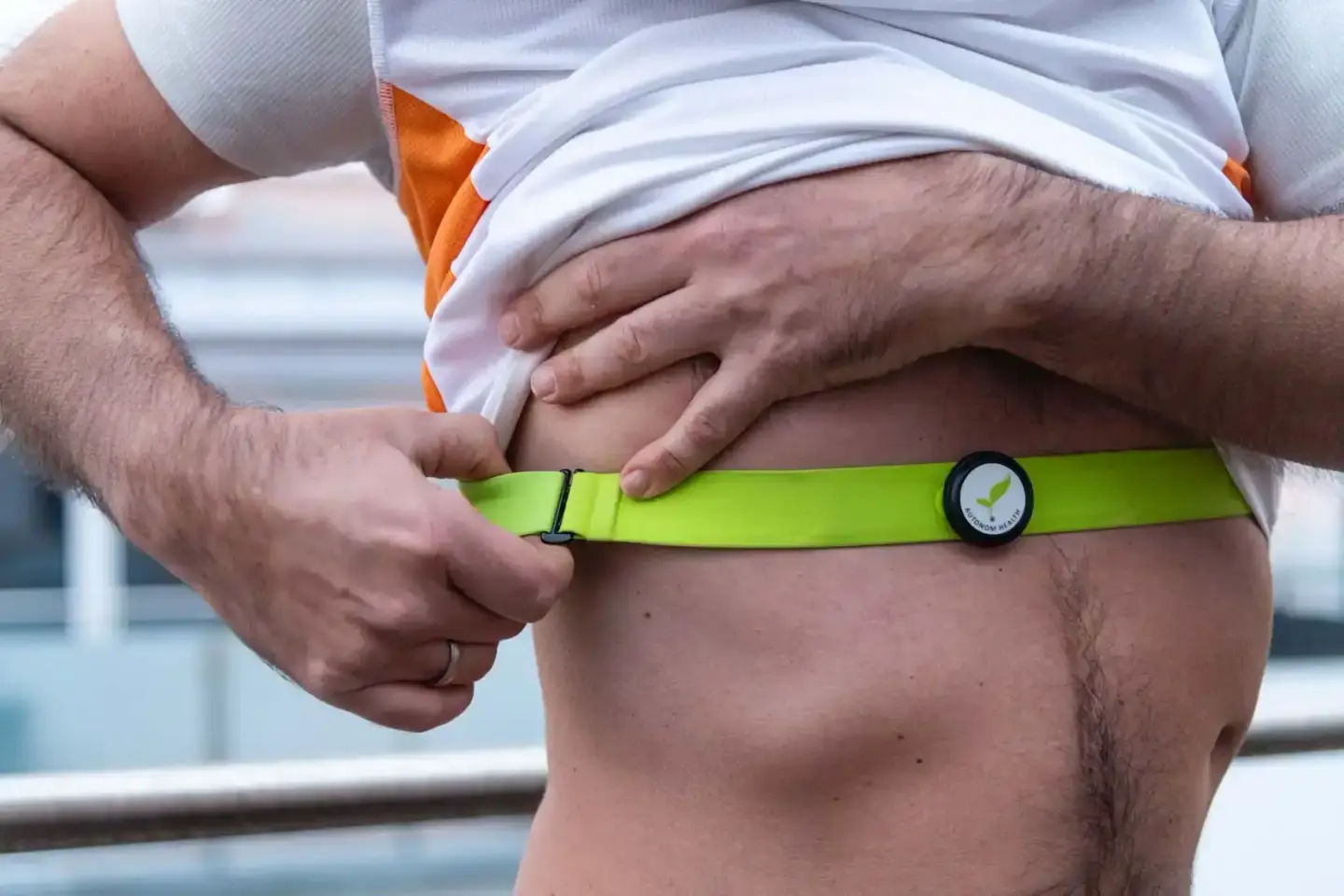 Mann mit Kind trägt grünes Fitness-Armband zur Gesundheitskontrolle – Produktfotografie Wien