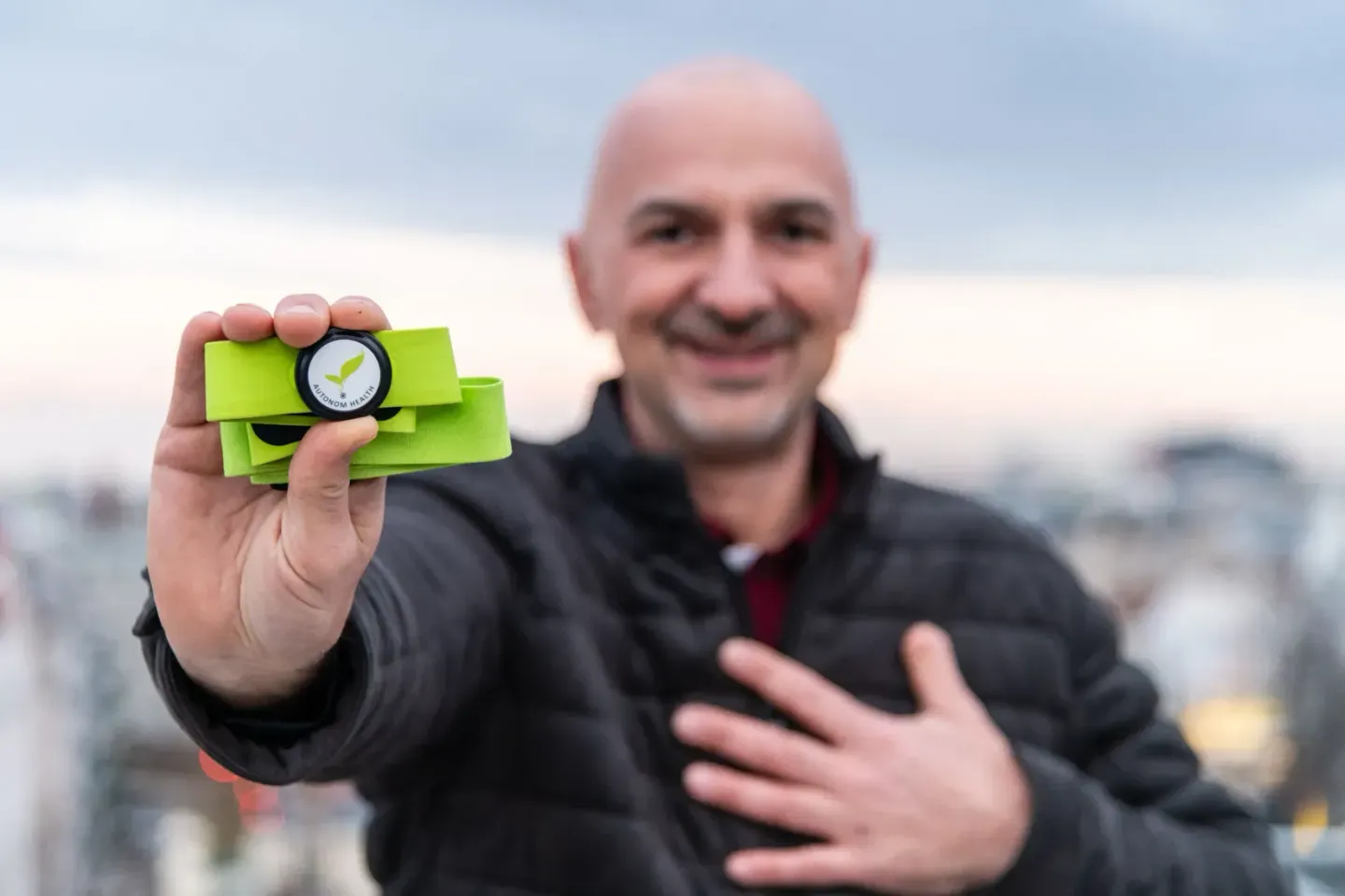 Produktfotograf in Wien präsentiert grünes Produktmuster mit Qualitätszertifikat vor Stadtpanorama