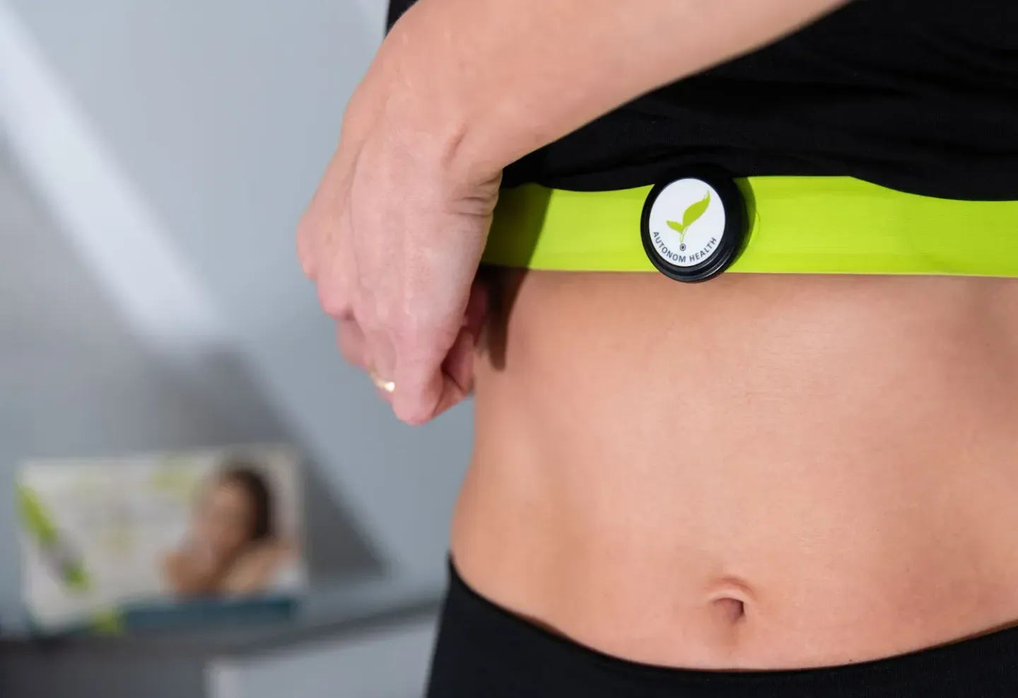 Frau trägt grünes Fitness-Armband mit Checkmark-Logo, Produktfotografie eines Wearables