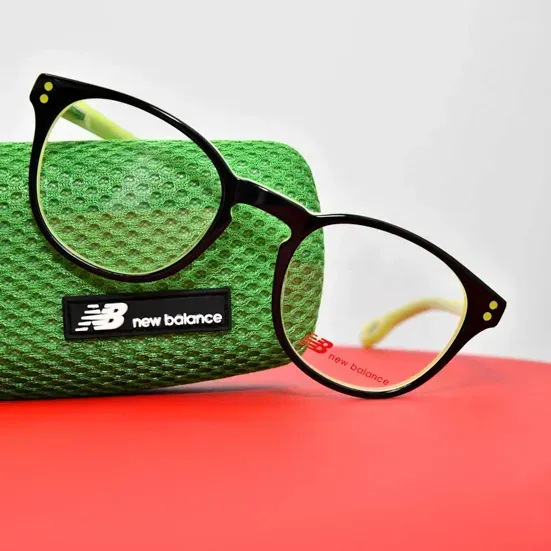 New Balance Brille auf grünem Textil und rotem Hintergrund – Produktfotografie Wien