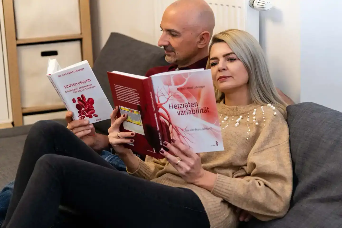 Zwei Personen auf einem Sofa präsentieren medizinische Fachbücher zur Produktfotografie Wien