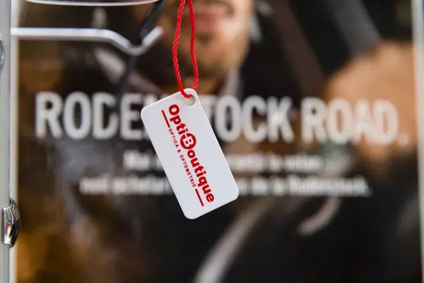 Weißes Produkttag mit rotem Logo hängend vor Rodeo Rock Road Poster - Produktfotografie Wien