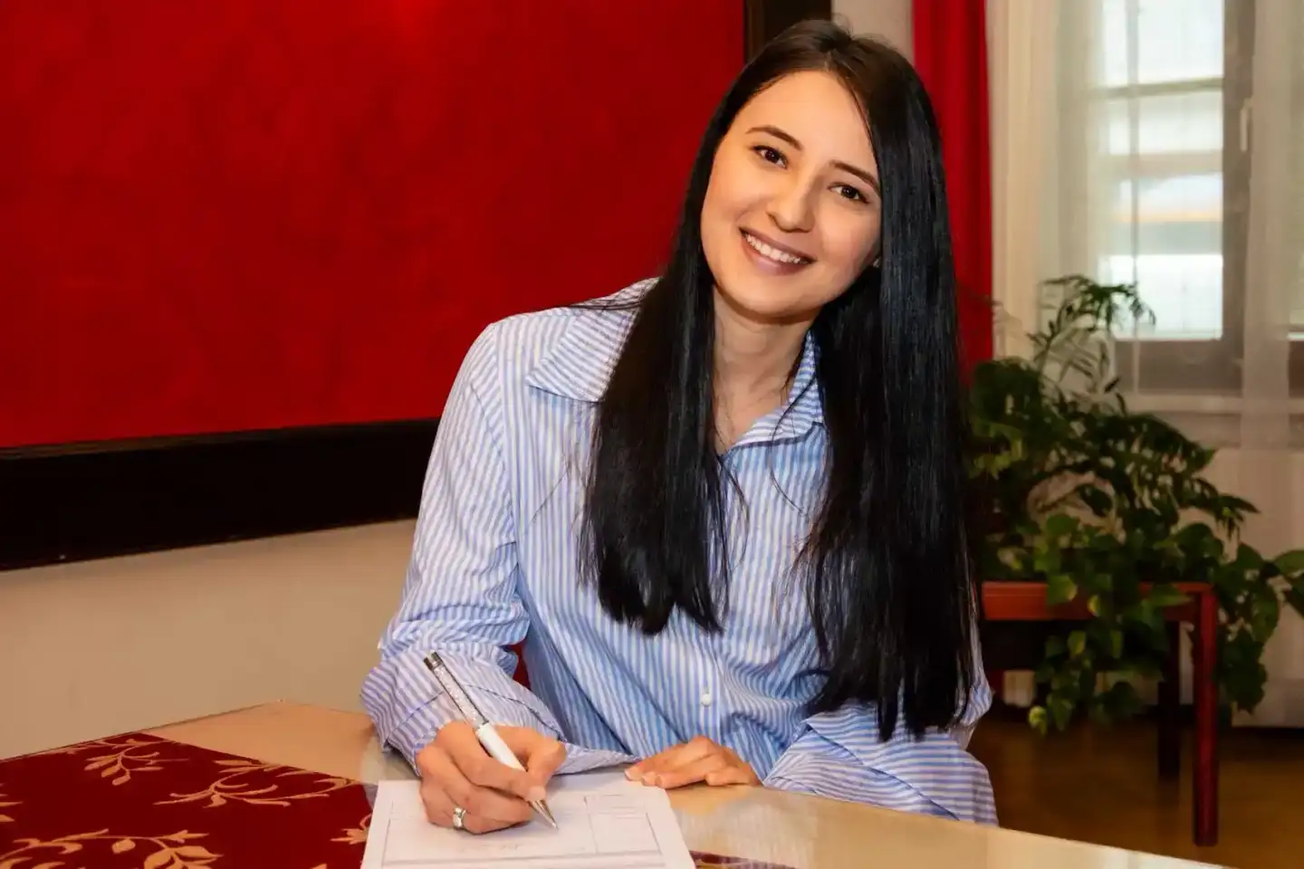 Braut beim Unterzeichnen der Hochzeitsurkunde - professionelle Hochzeitsfotografie Wien