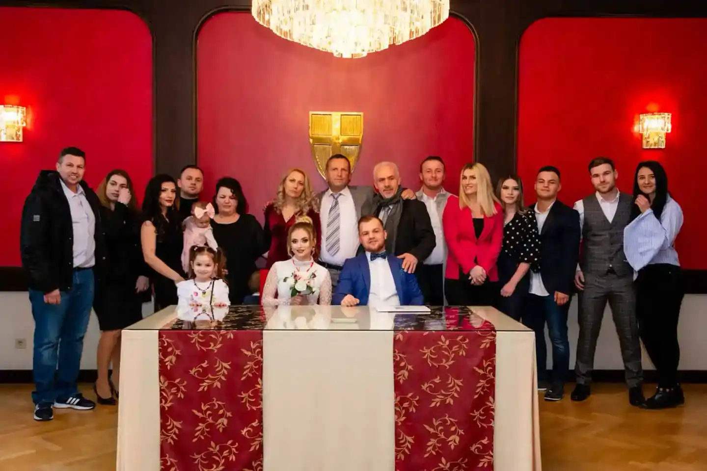 Brautpaar sitzt am Tisch mit Familie und Gästen im eleganten Saal, Hochzeitsfotograf Wien dokumentiert den Moment