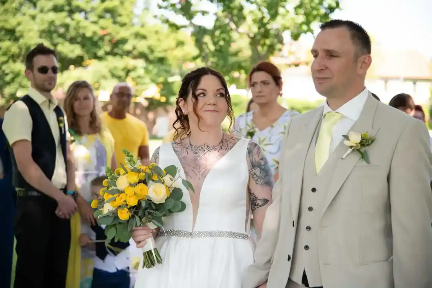 Brautpaar bei freier Trauung im Grünen - Hochzeitsfotografie Wien mit Braut in Weiß und Bräutigam im beigen Anzug